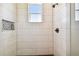 This shower boasts sleek white tiling, dark fixtures, and a convenient built-in niche at 7627 Artifact Dr, Zephyrhills, FL 33541