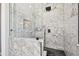 Modern shower with elegant marble tiling and black fixtures at 7627 Artifact Dr, Zephyrhills, FL 33541