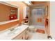 Well-lit bathroom with a shower-tub combo and sliding glass door, complemented by ample counter space at 8064 Brentwood Rd, Seminole, FL 33777