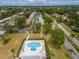 Aerial view featuring a community pool surrounded by landscaping, homes, and roadways at 8064 Brentwood Rd, Seminole, FL 33777