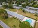 Aerial view of neighborhood, featuring a community pool, landscaping, and residential units at 8064 Brentwood Rd, Seminole, FL 33777