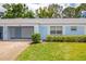 Single-story home with a one-car garage, blue paint, and well-maintained landscaping at 8064 Brentwood Rd, Seminole, FL 33777