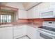 Bright kitchen featuring white appliances and cabinets with light pink countertops providing ample counter space at 8064 Brentwood Rd, Seminole, FL 33777