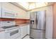 Well-lit kitchen featuring white appliances, ample cabinet space, and a modern stainless steel refrigerator at 8064 Brentwood Rd, Seminole, FL 33777