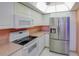 Bright kitchen features white cabinets, neutral countertops, and stainless steel refrigerator at 8064 Brentwood Rd, Seminole, FL 33777