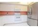 Bright kitchen with white appliances and cabinets and a large stainless steel refrigerator at 8064 Brentwood Rd, Seminole, FL 33777