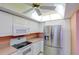 The kitchen features updated stainless steel refrigerator and white appliances at 8064 Brentwood Rd, Seminole, FL 33777
