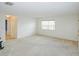 Inviting room with neutral carpet, a window with blinds, and easy access to other rooms at 8064 Brentwood Rd, Seminole, FL 33777