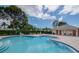 Beautiful community pool with building providing shade, chairs and lush landscaping for residents and guests at 8064 Brentwood Rd, Seminole, FL 33777