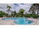 Beautiful community pool surrounded by chairs and lush landscaping on a bright, sunny day for residents and guests at 8064 Brentwood Rd, Seminole, FL 33777