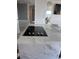 Elegant kitchen island featuring a smooth cooktop and gorgeous marble countertop at 880 Mandalay Ave # S302, Clearwater Beach, FL 33767