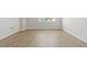 Cozy room with neutral paint, wood-look floors, and natural light from a window at 8848 Moonlit Meadows Loop, Riverview, FL 33578