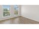 Bright bedroom with wood-look flooring and two large, arched windows at 8848 Moonlit Meadows Loop, Riverview, FL 33578