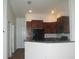 Kitchen featuring dark wood cabinets, breakfast bar, and modern appliances at 8848 Moonlit Meadows Loop, Riverview, FL 33578