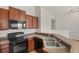 Bright kitchen with dark appliances and wrap-around bar at 8848 Moonlit Meadows Loop, Riverview, FL 33578