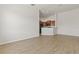 Spacious living room with neutral paint, wood-look floors, and open to kitchenette at 8848 Moonlit Meadows Loop, Riverview, FL 33578