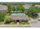 Aerial view of community pool with lounge chairs, landscaping, and surrounding buildings at 8848 Moonlit Meadows Loop, Riverview, FL 33578
