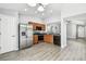 Modern kitchen with stainless steel appliances, wood cabinetry, and an open layout at 9551 Maxson Dr, Land O Lakes, FL 34638