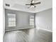 Spacious main bedroom with tray ceilings, wood-look floors, and dual windows for natural light at 9551 Maxson Dr, Land O Lakes, FL 34638