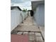 A side view of the property features pavers and new plantings between a white fence and the house at 10208 Oak Hill Dr, Port Richey, FL 34668