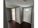 Inviting entryway featuring stylish dark wood floors, gray walls, and a traditional white front door at 10208 Oak Hill Dr, Port Richey, FL 34668