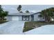Charming single-story home with a well-maintained front yard and attached garage, exuding curb appeal at 10208 Oak Hill Dr, Port Richey, FL 34668