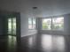 Bright, spacious living room with large windows and elegant tile flooring at 10208 Oak Hill Dr, Port Richey, FL 34668