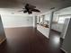 Open-concept living space with dark hardwood floors, ceiling fan, and view of kitchen at 10208 Oak Hill Dr, Port Richey, FL 34668