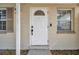 Close-up of the front door, featuring a secure lock system, a peephole, and a half-moon window above at 10381 108Th Ave, Largo, FL 33773