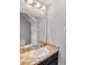 Elegant half bathroom features an attractive vanity with marble countertop and stylish lighting fixture at 10436 Rivercrest Dr, Riverview, FL 33578