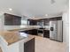 Well-equipped kitchen boasts stainless steel appliances, dark wood cabinets and elegant granite countertops at 10436 Rivercrest Dr, Riverview, FL 33578