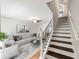 Bright living room features an open floor plan and wood staircase with white risers and decorative metal railings at 10436 Rivercrest Dr, Riverview, FL 33578