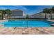 Community swimming pool with pristine blue water, brick pavers and surrounding community buildings at 10436 Rivercrest Dr, Riverview, FL 33578