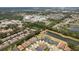 High-angle aerial view showcases a community interspersed with lakes, lush greenery, and nearby commercial developments at 10736 Whitland Grove Dr, Riverview, FL 33578