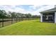 Large backyard offering a serene view of a pond, secured by a black iron fence, perfect for outdoor enjoyment at 10736 Whitland Grove Dr, Riverview, FL 33578