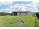 A well-maintained backyard showcasing a screened-in porch and a new tree at 10736 Whitland Grove Dr, Riverview, FL 33578