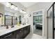 Bathroom showcasing double vanities, modern fixtures, and a view into the main bedroom at 10736 Whitland Grove Dr, Riverview, FL 33578