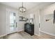 Bright foyer featuring a decorative dresser, modern chandelier, and a front door with privacy glass at 10736 Whitland Grove Dr, Riverview, FL 33578