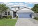Charming single-Gathering home with a blue garage door, manicured lawn, and lush landscaping at 10736 Whitland Grove Dr, Riverview, FL 33578
