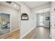 Hallway showcasing luxury vinyl floors, neutral paint, a decorative mirror, and an entryway at 10736 Whitland Grove Dr, Riverview, FL 33578