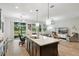 Open-concept kitchen with a large island, modern lighting, and stainless steel appliances at 10736 Whitland Grove Dr, Riverview, FL 33578