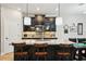Kitchen island with seating, modern pendant lighting, dark cabinets, and a tile backsplash at 10736 Whitland Grove Dr, Riverview, FL 33578