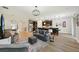 Open concept living room with luxury vinyl flooring, modern lighting, and dark kitchen cabinets at 10736 Whitland Grove Dr, Riverview, FL 33578