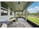 Covered screened-in porch with stylish furniture and a view of the landscaped backyard at 10736 Whitland Grove Dr, Riverview, FL 33578