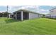A beautifully manicured lawn leads to a screened in porch in the backyard at 10736 Whitland Grove Dr, Riverview, FL 33578