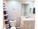 Bathroom featuring a white vanity, framed mirror, toilet and gray striped shower curtain at 11351 Shipwatch Ln # 1844, Largo, FL 33774