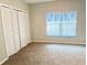 Spacious bedroom with neutral carpet, closet with bifold doors and a window with blinds at 11351 Shipwatch Ln # 1844, Largo, FL 33774