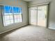 Bedroom with neutral carpet, a window and a sliding glass door out to the sunroom at 11351 Shipwatch Ln # 1844, Largo, FL 33774