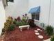 Beautiful landscaped yard with bench, flowering plants, bark, and awning over window at 11351 Shipwatch Ln # 1844, Largo, FL 33774