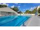Community pool with clear blue water, marked lanes, lounge chairs, and umbrellas for relaxation at 11351 Shipwatch Ln # 1844, Largo, FL 33774